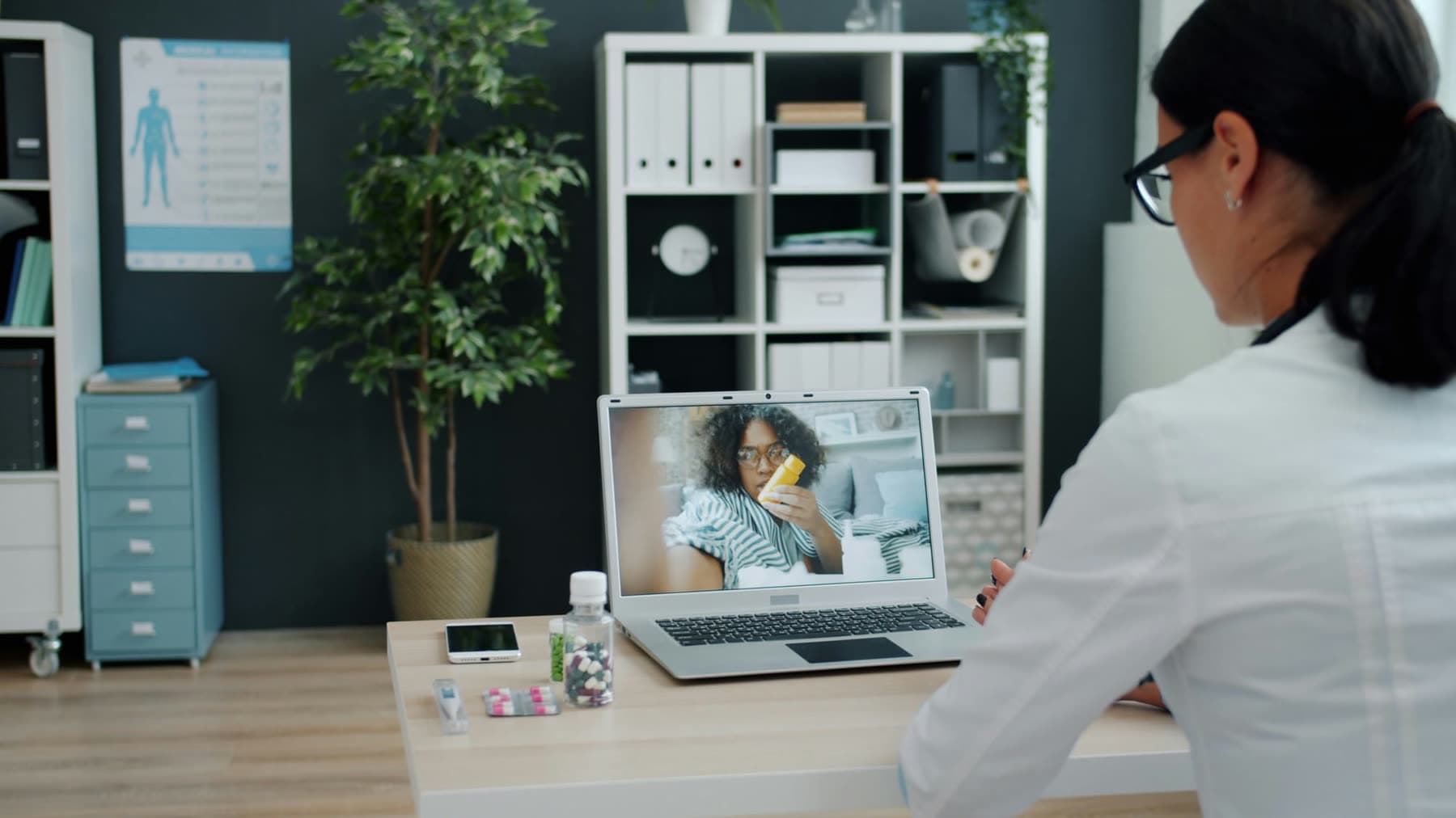 Médica atendendo por videochamada do consultório
