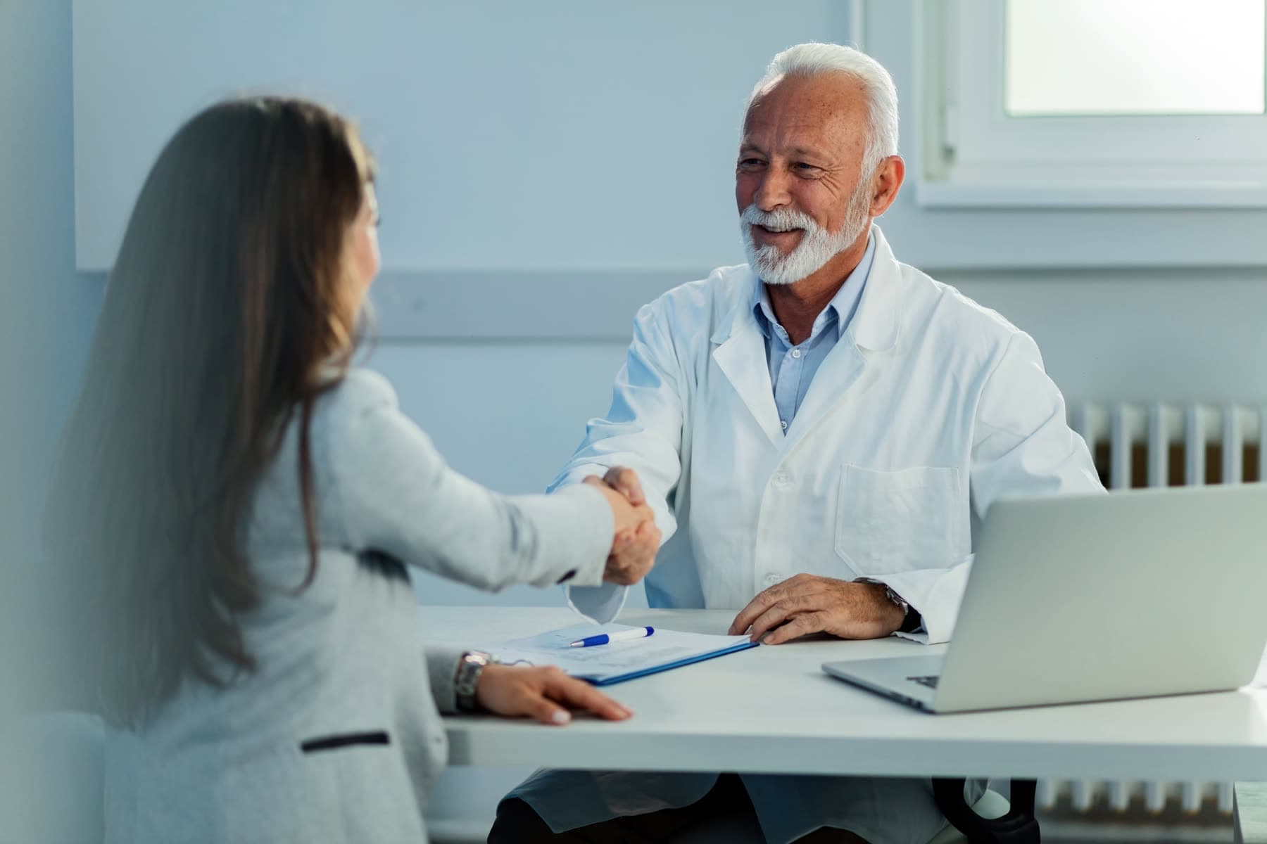 Médico cumprimentando uma paciente ao final da consulta